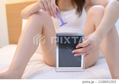 VIOデリケートゾーン股間のセルフケアをする若い女性　鏡を見ながらT字カミソリで剃毛　除毛　 118691203