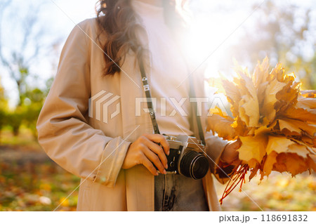 Woman taking pictures in autumn forest. Smiling woman enjoying autumn weather. Lifestyle concept. Woman taking pictures in autumn forest. Smiling woman enjoying autumn weather. Lifestyle concept. 118691832