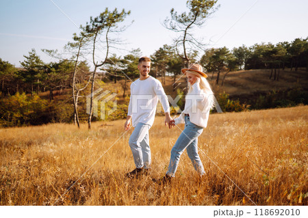Young couple having fun walking and hugging n the park. Autumn weather. Relaxation, youth. 118692010