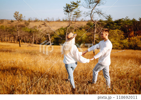 Young couple having fun walking and hugging n the park. Autumn weather. Relaxation, youth. 118692011