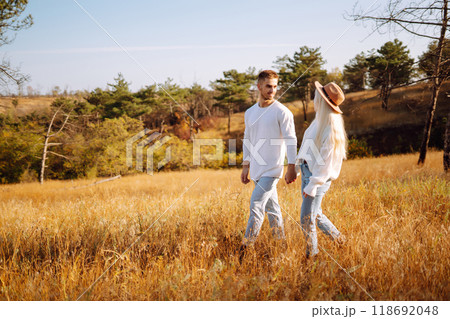 Young couple having fun walking and hugging n the park. Autumn weather. Relaxation, youth. 118692048