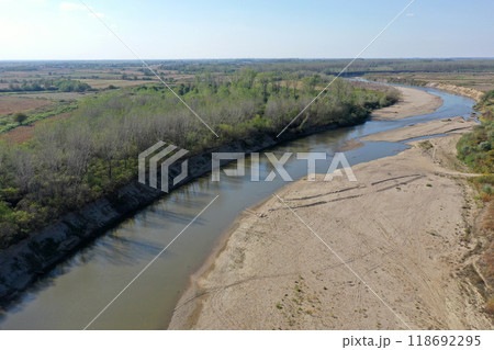 Flying over a river flowing on a plain aerial view 118692295