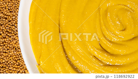 Mustard sauce and dry mustard seeds close-up Mustard sauce and dry mustard seeds close-up 118692922