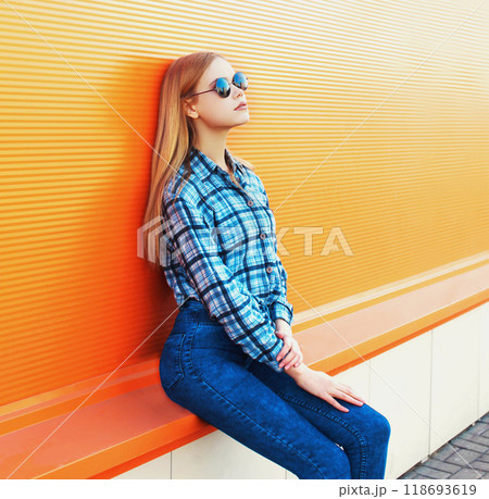 Fashion beautiful blonde woman posing on a colorful orange background 118693619