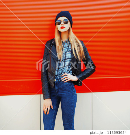 Fashion portrait beautiful blonde woman in rock black style on red background in city Fashion portrait beautiful blonde woman in rock black style on red background in city 118693624