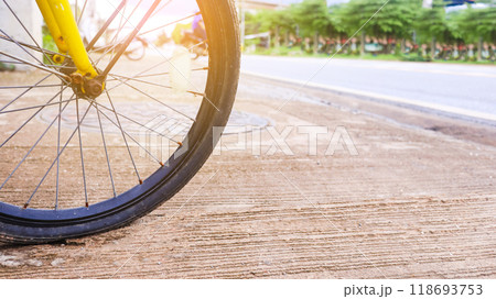 Wheel of a bicycle is flat parking on concrete sidewalk beside a road, need to be repaired, the moment of stillness and an unexpected pause in a journey. Wheel of a bicycle is flat parking on concrete sidewalk beside a road, need to be repaired, the moment of stillness and an unexpected pause in a journey. 118693753