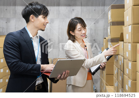 倉庫で商品のチェックをする社員 118694525