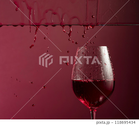 Red wine flows down into a glass. 118695434