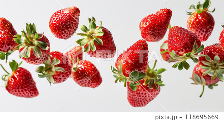 Whole ripe raw strawberries with drops of water flying in the air, isolated on white background 118695669