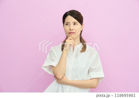 上を見上げて、考え事をしている若い女性 118695981
