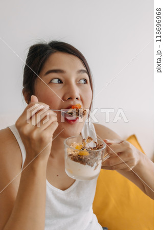 Happy woman eating healthy homemade snack made of yogurt. Happy woman eating healthy homemade snack made of yogurt. 118696968