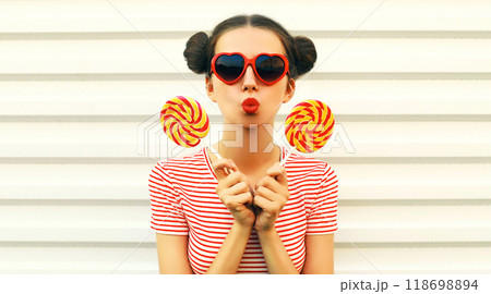 Portrait stylish young woman blowing kiss with red lipstick with cool hairstyle on white background Portrait stylish young woman blowing kiss with red lipstick with cool hairstyle on white background 118698894