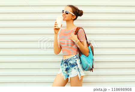 Portrait of happy smiling young woman drinking coffee with cool hairstyle on white background Portrait of happy smiling young woman drinking coffee with cool hairstyle on white background 118698908