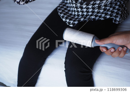 Utilizing a Lint Roller on Dark Pants Ensures a Neat and Clean Look for Your Outfit 118699306