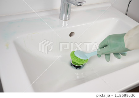 Cleaning aToilet Sink Effectively Using a Sponge and Wearing Gloves for Protection Cleaning aToilet Sink Effectively Using a Sponge and Wearing Gloves for Protection 118699330