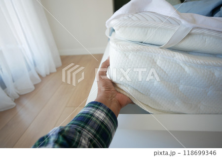 Placing the white sheet on the mattress for added comfort 118699346