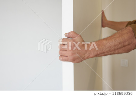 Hand Grip on Door Frame in a Sleek and Modern Interior Space with an Emphasis on Style Hand Grip on Door Frame in a Sleek and Modern Interior Space with an Emphasis on Style 118699356