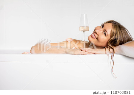 A young, beautiful, smiling, sexy and happy woman with long hair takes a bath with foam 118703081