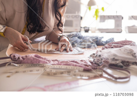 A woman seamstress designs and draws a pattern for underwear on graph paper.  118703098