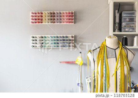 Sewing workshop. Mannequin for trying on clothes. Multi-colored threads for sewing. Sewing workshop. Mannequin for trying on clothes. Multi-colored threads for sewing. 118703128