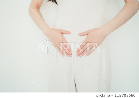 下腹部を手でさする女性 118705660