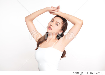 Beautiful Young Asian woman lifting hands up to show off clean and hygienic armpits or underarms on white background, Smooth armpit cleanliness and protection concept 118705750