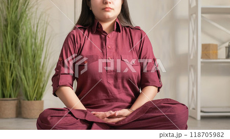 Meditation morning. Mindfulness exercise. Unrecognizable tranquil woman sitting in lotus pose mudra dhyana gesture concentrated on breathing indoors at home. 118705982