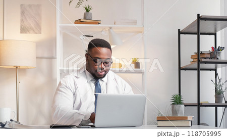 Hospital report. Computer work. Medical professional. Serious focused man physician doctor typing diagnosis treatment on laptop at clinic workplace desk. 118705995