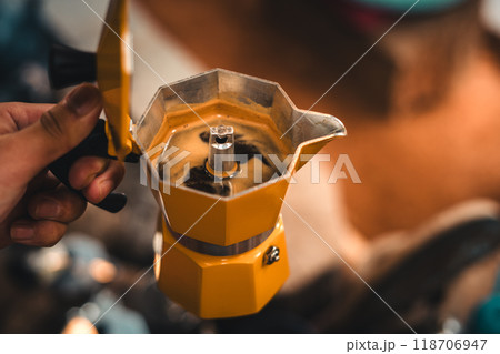 Hand holding coffee from a moka pot Hand holding coffee from a moka pot 118706947