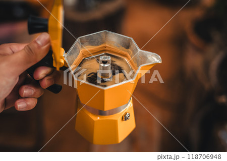 Hand holding coffee from a moka pot Hand holding coffee from a moka pot 118706948