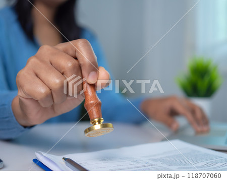 Businesswoman hand stamping with approved stamp on text approved document at desk, Validates and manages business documents and agreements, Approval stamp, Signing on business partner paper to success 118707060