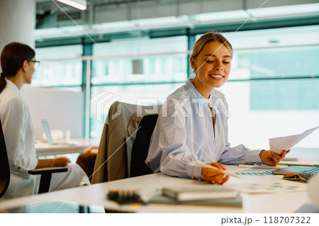 Young Professionals Excitedly Collaborating in a Modern Office Working Environment Young Professionals Excitedly Collaborating in a Modern Office Working Environment 118707322