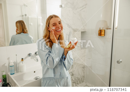 A Woman Delighting in Her Skincare Routine in a Bright and Inviting Bathroom Space A Woman Delighting in Her Skincare Routine in a Bright and Inviting Bathroom Space 118707341
