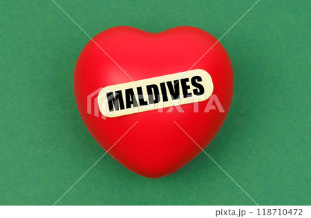 On a green surface lies a red heart with the inscription - Maldives 118710472
