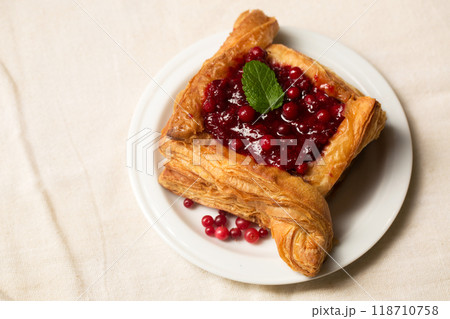 A delicious dessert, puff pastry cake with berry filling on a light color 118710758