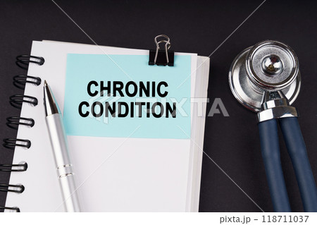 On a black surface, a stethoscope, a notebook, a pen and a blue sticker with the inscription - CHRONIC CONDITION On a black surface, a stethoscope, a notebook, a pen and a blue sticker with the inscription - CHRONIC CONDITION 118711037