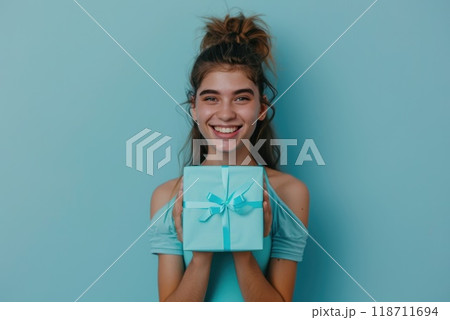 Happy birthday girl with a gift in her hands on a blue background 118711694