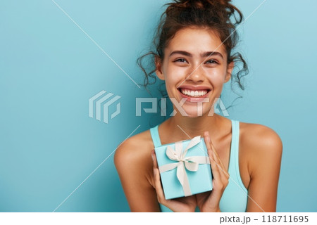 Happy birthday girl with a gift in her hands on a blue background 118711695