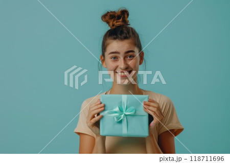 Happy birthday girl with a gift in her hands on a blue background 118711696