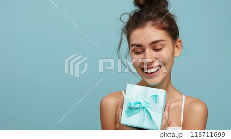Happy birthday girl with a gift in her hands on a blue background 118711699