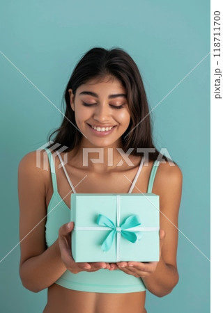 Happy birthday girl with a gift in her hands on a blue background 118711700