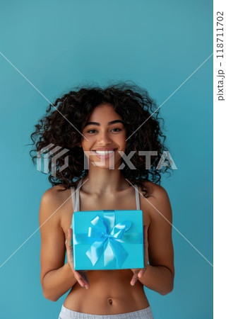 Happy birthday girl with a gift in her hands on a blue background 118711702