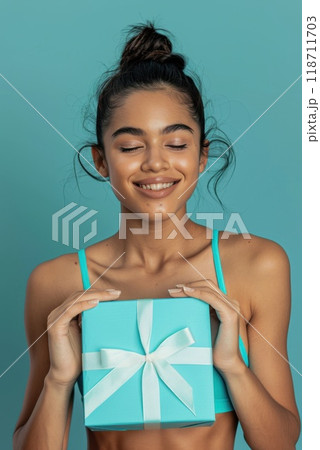 Happy birthday girl with a gift in her hands on a blue background 118711703