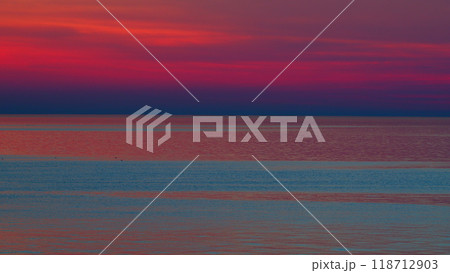 Bright Sun On Horizon Over Water During Sunset. Beautiful Purple Or Pink And Violet Sunset Above Sea. 118712903