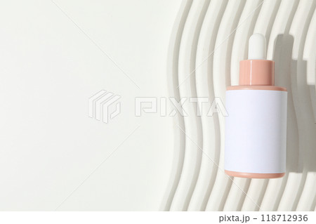 Cosmetic oil in a bottle on a light background 118712936