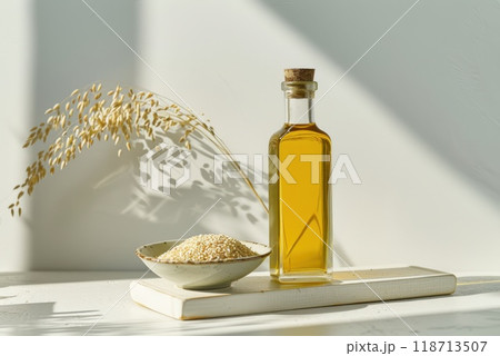 Sesame oil in a bottle and sesame seeds in a plate on the table Sesame oil in a bottle and sesame seeds in a plate on the table 118713507