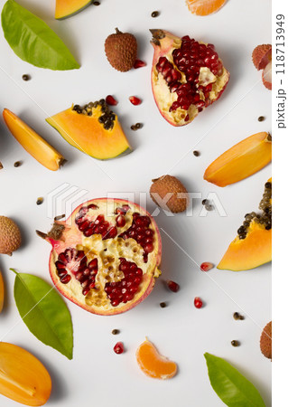 Fruit background made of pieces of ripe papaya, garnet and litchi on a white background Fruit background made of pieces of ripe papaya, garnet and litchi on a white background 118713949