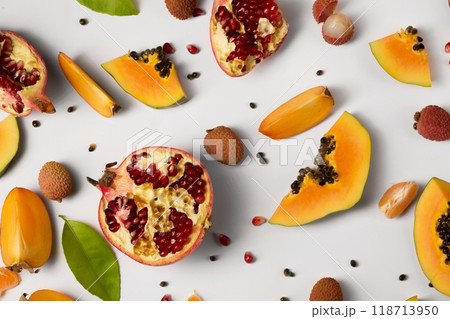 Fruit background made of pieces of ripe papaya, garnet and litchi Fruit background made of pieces of ripe papaya, garnet and litchi 118713950