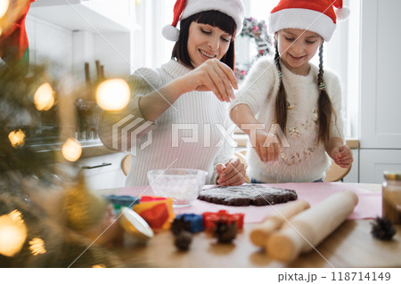 Mother and daughter baking Christmas cookies with joy and laughter Mother and daughter baking Christmas cookies with joy and laughter 118714149