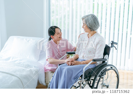 介護施設で暮らすシニア女性と若い介護士 118715362